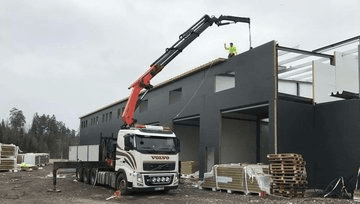 Kranbil levererar byggmaterial till byggarbetsplats